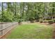 Large backyard with grass, mature trees, and a wooden fence, providing privacy at 410 Dalrymple Ne Rd, Atlanta, GA 30328