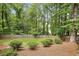 Lush backyard features green grass, manicured bushes, and a privacy fence surrounded by mature trees at 410 Dalrymple Ne Rd, Atlanta, GA 30328