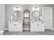 Bright bathroom featuring double vanities with round mirrors and open shelving for storage at 410 Dalrymple Ne Rd, Atlanta, GA 30328