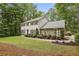 Charming two-story home featuring a stone and shingle facade, manicured landscaping, and mature trees at 410 Dalrymple Ne Rd, Atlanta, GA 30328