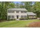 Charming two-story home with a stone and shingle facade, manicured landscaping, and mature shade trees at 410 Dalrymple Ne Rd, Atlanta, GA 30328