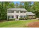 Charming two-story home with grey shake siding, black shutters, and a lush green lawn at 410 Dalrymple Ne Rd, Atlanta, GA 30328