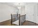 Hallway showcasing hardwood floors, iron railings, a stylish chandelier, and white walls with trim at 410 Dalrymple Ne Rd, Atlanta, GA 30328