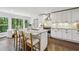 Eat-in kitchen features white cabinets, stainless steel appliances, a marble island, and dark hardwood floors at 410 Dalrymple Ne Rd, Atlanta, GA 30328