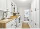 A spacious laundry room with butcher block counters, white cabinets, and stylish fixtures at 410 Dalrymple Ne Rd, Atlanta, GA 30328
