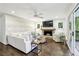 A bright living room featuring a stone fireplace, hardwood floors, shiplap walls, and sliding door access to a balcony at 410 Dalrymple Ne Rd, Atlanta, GA 30328