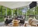 Screened-in porch features comfortable seating and views of the wooded backyard, perfect for outdoor relaxation at 410 Dalrymple Ne Rd, Atlanta, GA 30328