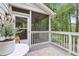 Inviting screened porch with white railings, a comfortable seating area, and views of the surrounding greenery at 410 Dalrymple Ne Rd, Atlanta, GA 30328