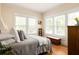 Bright bedroom with hardwood floors, three windows, and a dresser with white trim at 492 Clifton Ne Rd, Atlanta, GA 30307