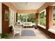 Inviting front porch with swing, wicker chairs, and brick columns for relaxing at 492 Clifton Ne Rd, Atlanta, GA 30307