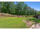 Large backyard with lush green grass and a privacy fence backing up to trees at 51 Queen Anne Se Dr, Mableton, GA 30126