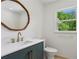 Stylish bathroom with wood trim mirror, blue vanity, and gold fixtures at 51 Queen Anne Se Dr, Mableton, GA 30126