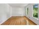 Bright bedroom with hardwood floors and dual windows offering lovely outdoor views, enhanced by a fresh, white decor at 51 Queen Anne Se Dr, Mableton, GA 30126