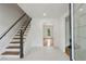 Bright entryway featuring tile floors, wooden stairs with black rails, and views into the adjacent living spaces at 51 Queen Anne Se Dr, Mableton, GA 30126