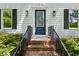 Inviting entrance with a navy blue front door, brick steps, manicured hedges, and stylish lighting fixtures at 51 Queen Anne Se Dr, Mableton, GA 30126