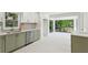 Modern kitchen with olive green cabinets, stainless steel appliances, and a clear view of the bright sunroom at 51 Queen Anne Se Dr, Mableton, GA 30126