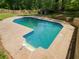 A refreshing in-ground swimming pool surrounded by a concrete patio and lush greenery at 51 Queen Anne Se Dr, Mableton, GA 30126