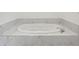 Close-up view of a built-in soaking tub with marble surround at 51 Queen Anne Se Dr, Mableton, GA 30126
