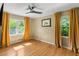Bedroom with ceiling fan, hardwood floors, and windows with gold curtains, providing ample natural light at 1652 Oak Grove Rd, Decatur, GA 30033