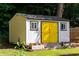 Backyard shed with bright yellow doors and fresh flowers, perfect for storage at 1652 Oak Grove Rd, Decatur, GA 30033