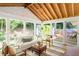 Bright sunroom with wood ceiling, many windows and views of the lush landscaped backyard with deck at 1652 Oak Grove Rd, Decatur, GA 30033