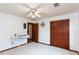 Bedroom features white walls and carpet, ceiling fan, closet, and ironing board at 203 Leigh Dr, Ellenwood, GA 30294