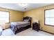 Cozy bedroom features neutral carpet, walls, natural light from two windows, and a wooden frame bed set at 203 Leigh Dr, Ellenwood, GA 30294