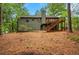 Exterior of the home featuring a wooden deck, a chimney, and wooded backyard at 4788 Rock Island Nw Ln, Acworth, GA 30102