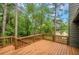 A wooden deck with brown wooden railings overlooks a lush, wooded backyard at 4788 Rock Island Nw Ln, Acworth, GA 30102