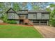 Split-level home with an olive exterior, deck, two-car garage, and green lawn at 4788 Rock Island Nw Ln, Acworth, GA 30102