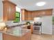 Eat-in kitchen featuring wood cabinets, black appliances, and neutral countertops at 4788 Rock Island Nw Ln, Acworth, GA 30102