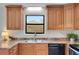Galley kitchen featuring wood cabinets, black appliances, and neutral countertops at 4788 Rock Island Nw Ln, Acworth, GA 30102