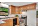 Eat-in kitchen featuring wood cabinets, black appliances, and neutral countertops at 4788 Rock Island Nw Ln, Acworth, GA 30102