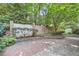 Lush backyard features a brick wall, brick pathway, and mature trees at 12 Westchester Square Sq, Decatur, GA 30030