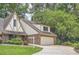 Tudor-style home featuring a brick facade, attached two-car garage and lush green landscaping at 12 Westchester Square Sq, Decatur, GA 30030
