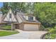 Lovely Tudor-style home with an attached two-car garage, brick accents, and mature trees at 12 Westchester Square Sq, Decatur, GA 30030