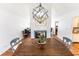 Inviting dining area with a large wooden table, modern chandelier, and view of the cozy fireplace at 150 Newton Ridge Dr, Covington, GA 30014