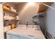 Close up of a laundry room that has a pair of modern, white washing machines and storage at 150 Newton Ridge Dr, Covington, GA 30014