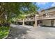 Townhome garages with upper patios and black asphalt driveway under shade trees at 1534 September Chase, Decatur, GA 30033