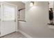 Bright entryway with tile flooring, a white door with sidelight, and classic wall sconce at 1634 Ponce De Leon Ave # 107, Atlanta, GA 30307