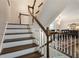 Elegant staircase featuring white spindles and wooden handrail leads to a sunlit dining area with stylish light fixture at 1634 Ponce De Leon Ave # 107, Atlanta, GA 30307