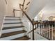 Hardwood staircase leading to an open-concept dining area with stylish lighting and sophisticated decor at 1634 Ponce De Leon Ave # 107, Atlanta, GA 30307