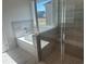 Bathroom including separate shower and tub with elegant tile work and a bright window at 306 Rodeo Dr, Auburn, GA 30102