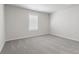 Bright bedroom with plush gray carpet and natural light from a window at 306 Rodeo Dr, Auburn, GA 30102