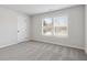 Well-lit bedroom featuring plush gray carpet, white trim, and a window view at 306 Rodeo Dr, Auburn, GA 30102