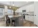Bright, modern kitchen featuring white cabinets, stainless steel appliances, and a stylish island with bar seating at 316 Rodeo Dr, Auburn, GA 30102