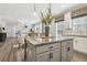 Bright kitchen featuring an island with granite countertops, modern pendant lighting, and an open view to the living area at 306 Rodeo Dr, Auburn, GA 30102