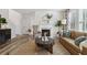 Comfortable living room featuring fireplace, hardwood floors, cozy furniture, and natural light streaming through the windows at 306 Rodeo Dr, Auburn, GA 30102
