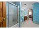 A bathroom with blue floral wallpaper, a shower with glass doors, and a wood vanity at 110 The Farm Rd, Mcdonough, GA 30252