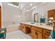 Bright bathroom with skylight, double sink vanity, large mirror, and tiled tub at 110 The Farm Rd, Mcdonough, GA 30252